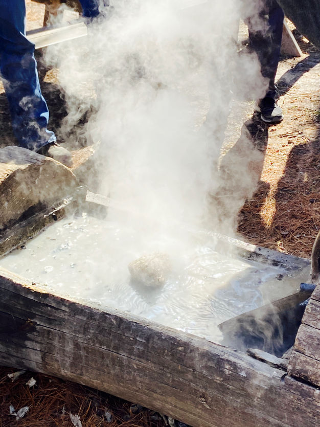 Photo of steam evaporating from log with maple sap