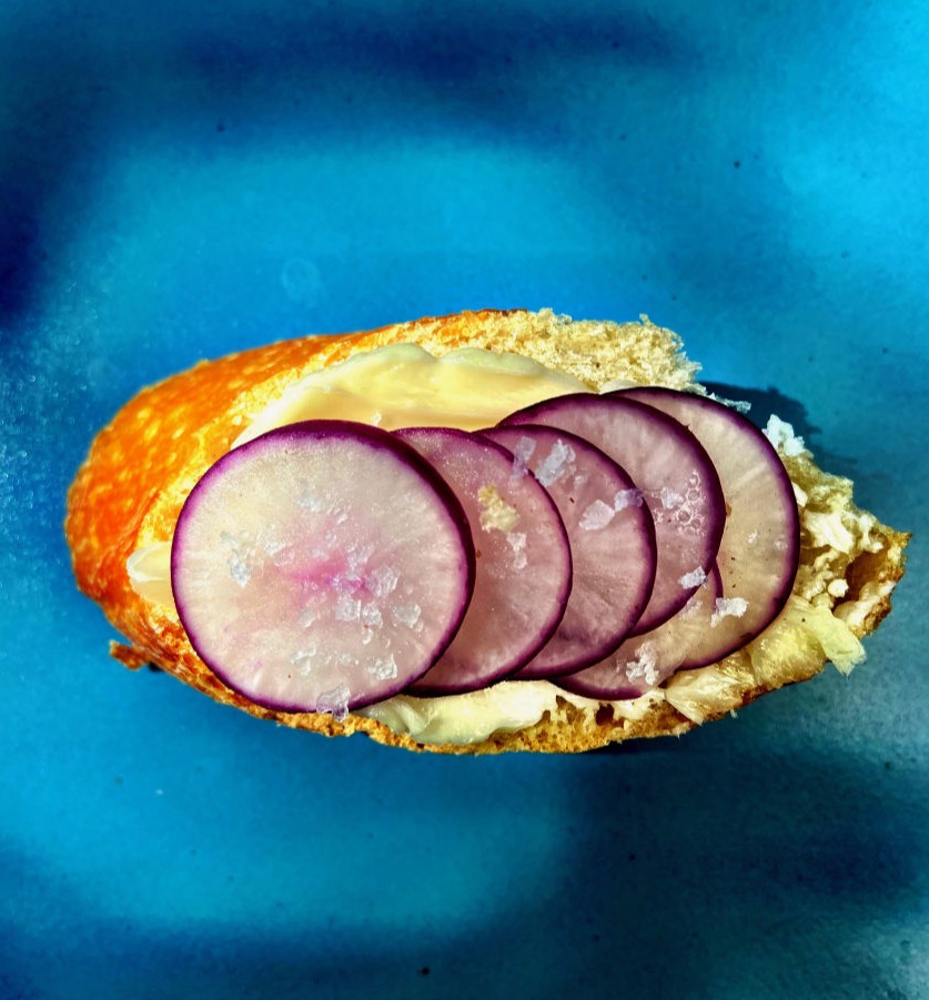 Photo of sliced radishes on bread and butter